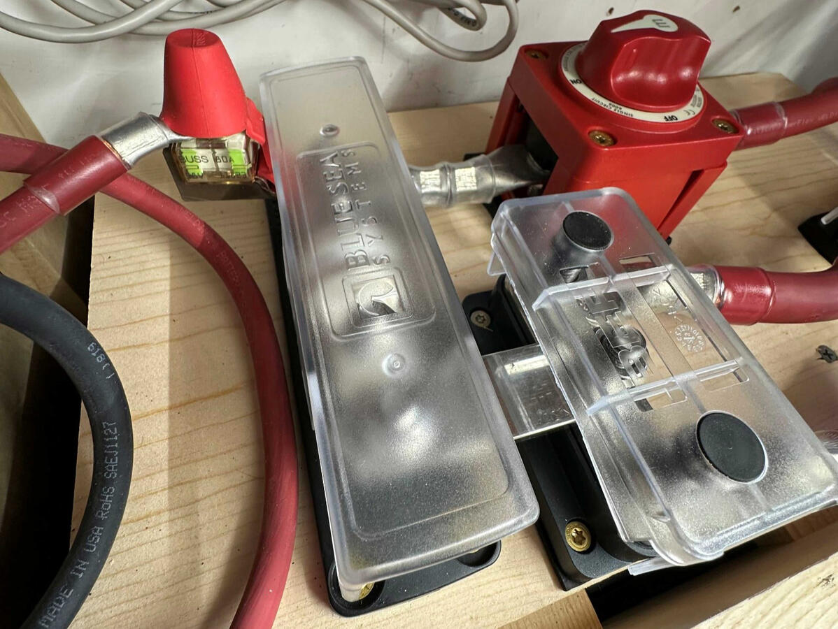 Custom camper van electrical installation with Blue Sea Class T battery fuse protection, heavy-duty battery disconnect switch, and 4/0 power cables.
